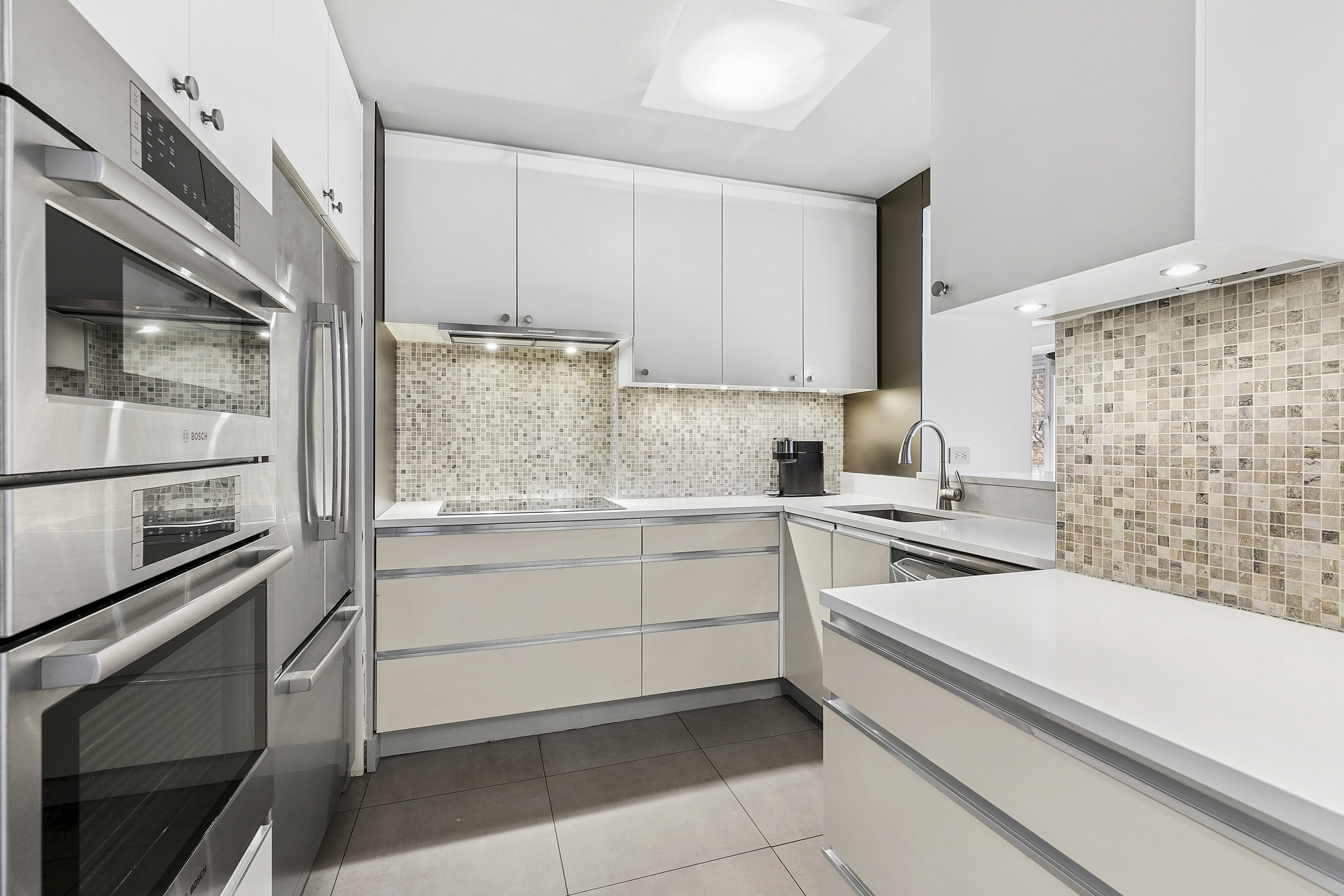 1065 Park Avenue, Unit 4BC Manhattan, NY 10128 - Photo 4 of 16 a kitchen with a sink stove and microwave