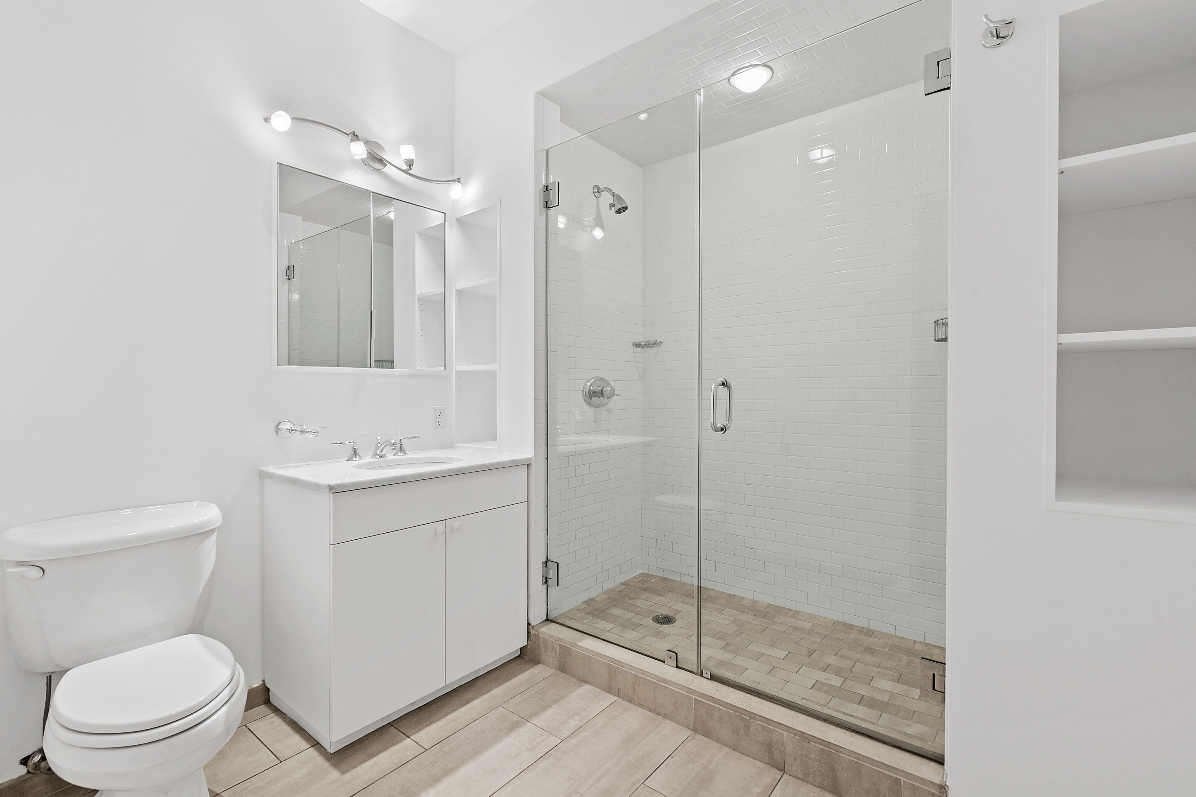 40 West 17th Street, Unit 3B Manhattan, NY 10011 - Photo 5 of 7 a bathroom with a shower sink mirror and toilet