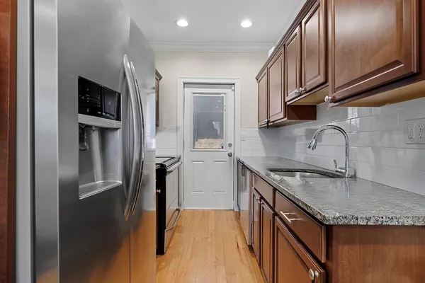 a kitchen with granite countertop stainless steel appliances and wooden cabinets