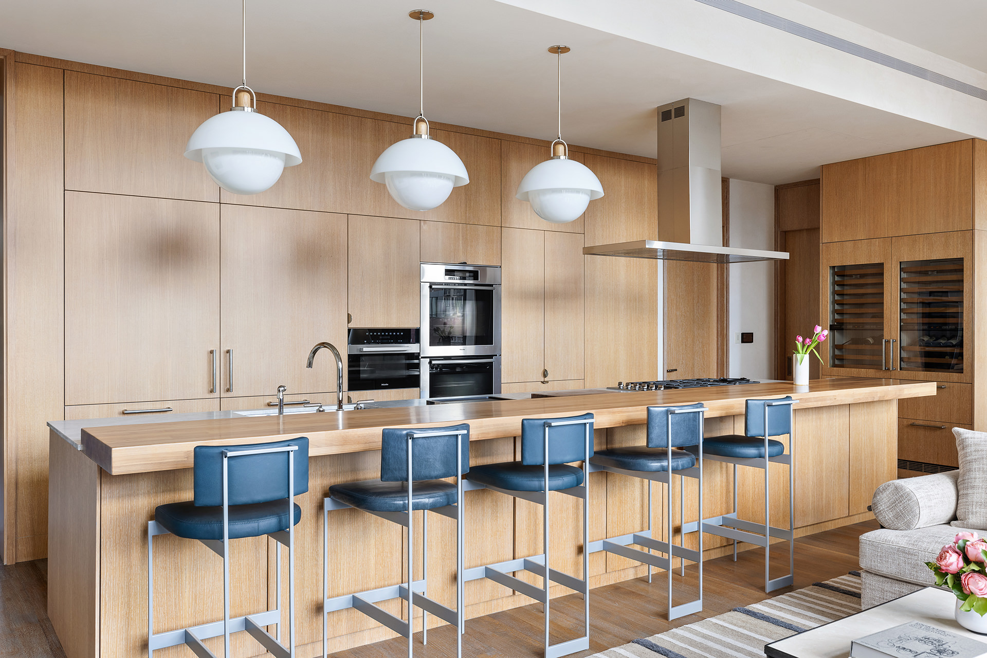 25 Bond Street, Unit PHW Manhattan, NY 10012 - Photo 11 of 34 a kitchen with stainless steel appliances kitchen island granite countertop a table and chairs in it