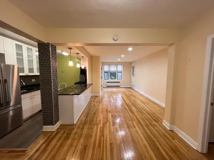a view of a living room with wooden floor and a large window