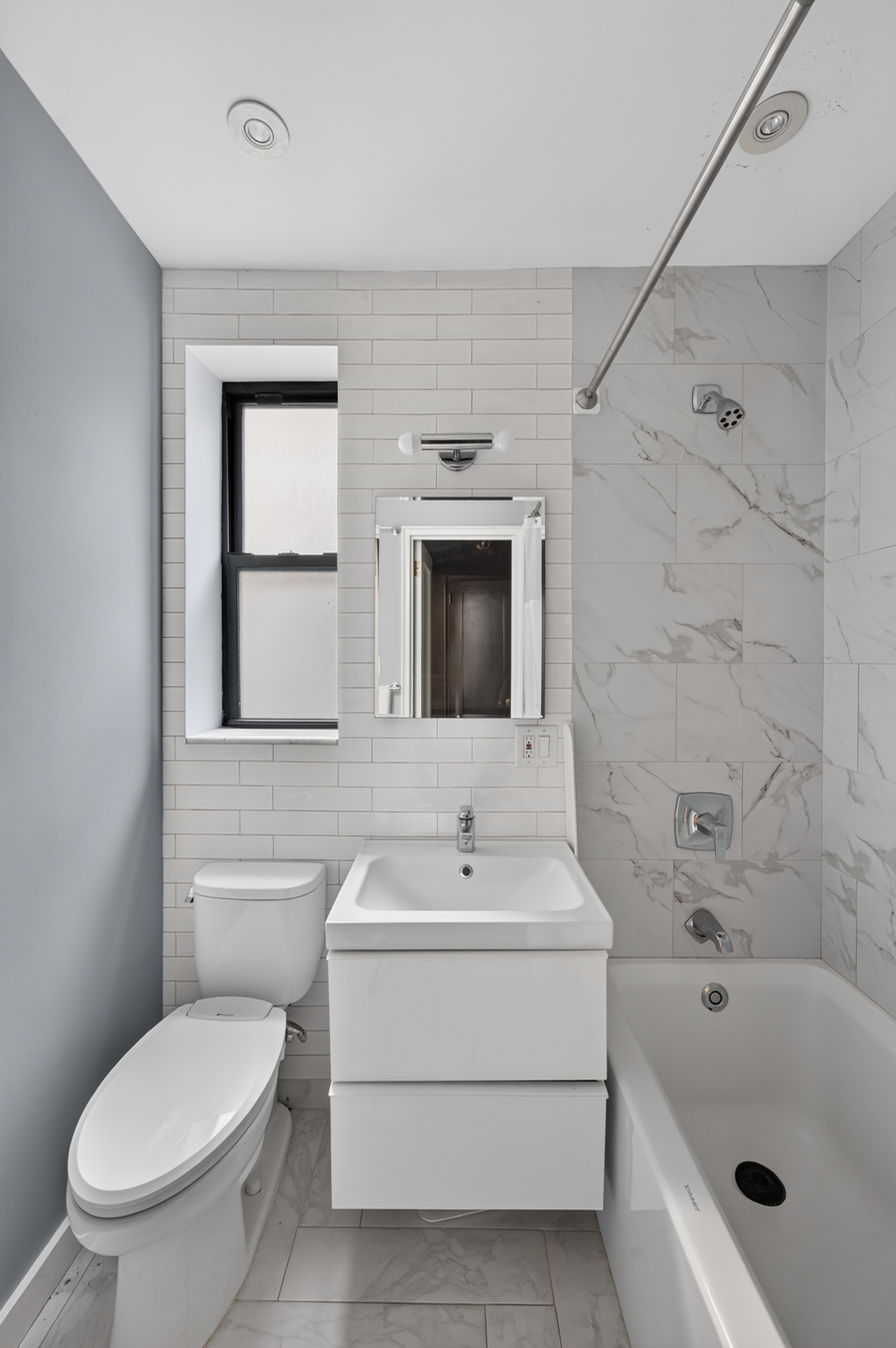 303 East 37th Street, Unit 5B Manhattan, NY 10016 - Photo 6 of 8 a bathroom with a sink a toilet and shower