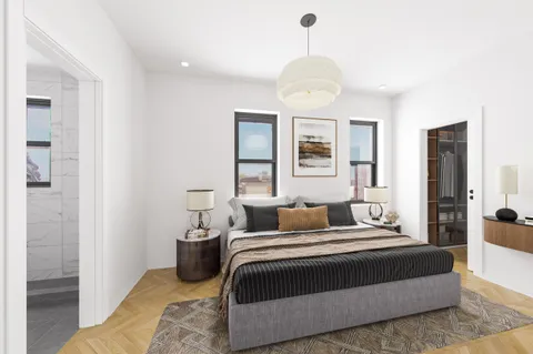 a bedroom with a large bed and a chandelier