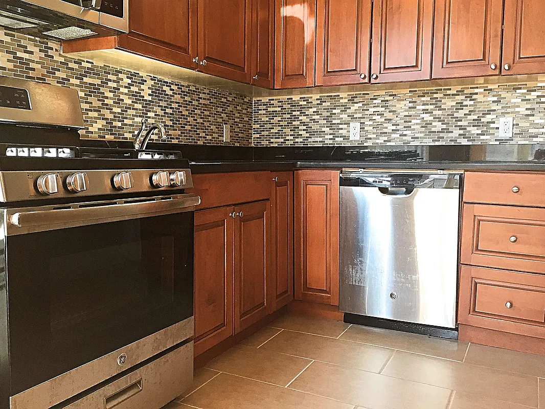 a kitchen with granite countertop a stove and a refrigerator