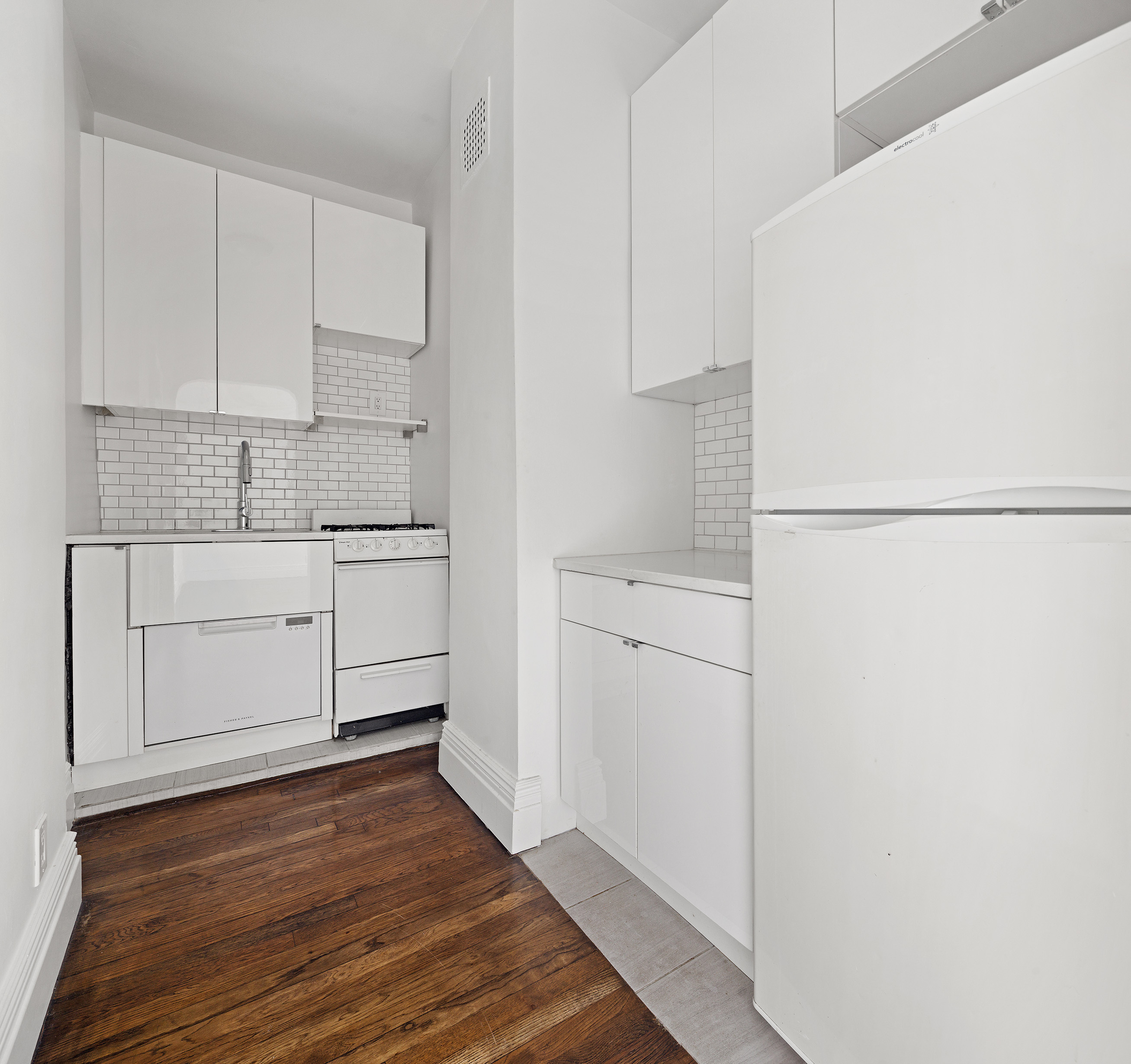 10 Bethune Street, Unit 2B Manhattan, NY 10014 - Photo 5 of 7 a kitchen with white cabinets and white appliances
