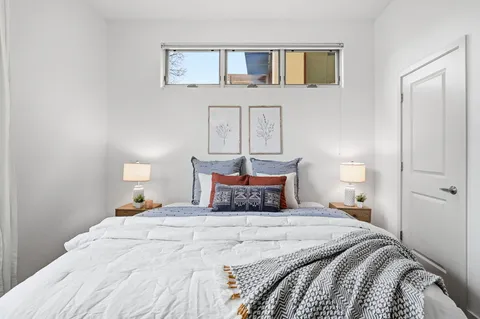 a bedroom with a bed and painting on the wall