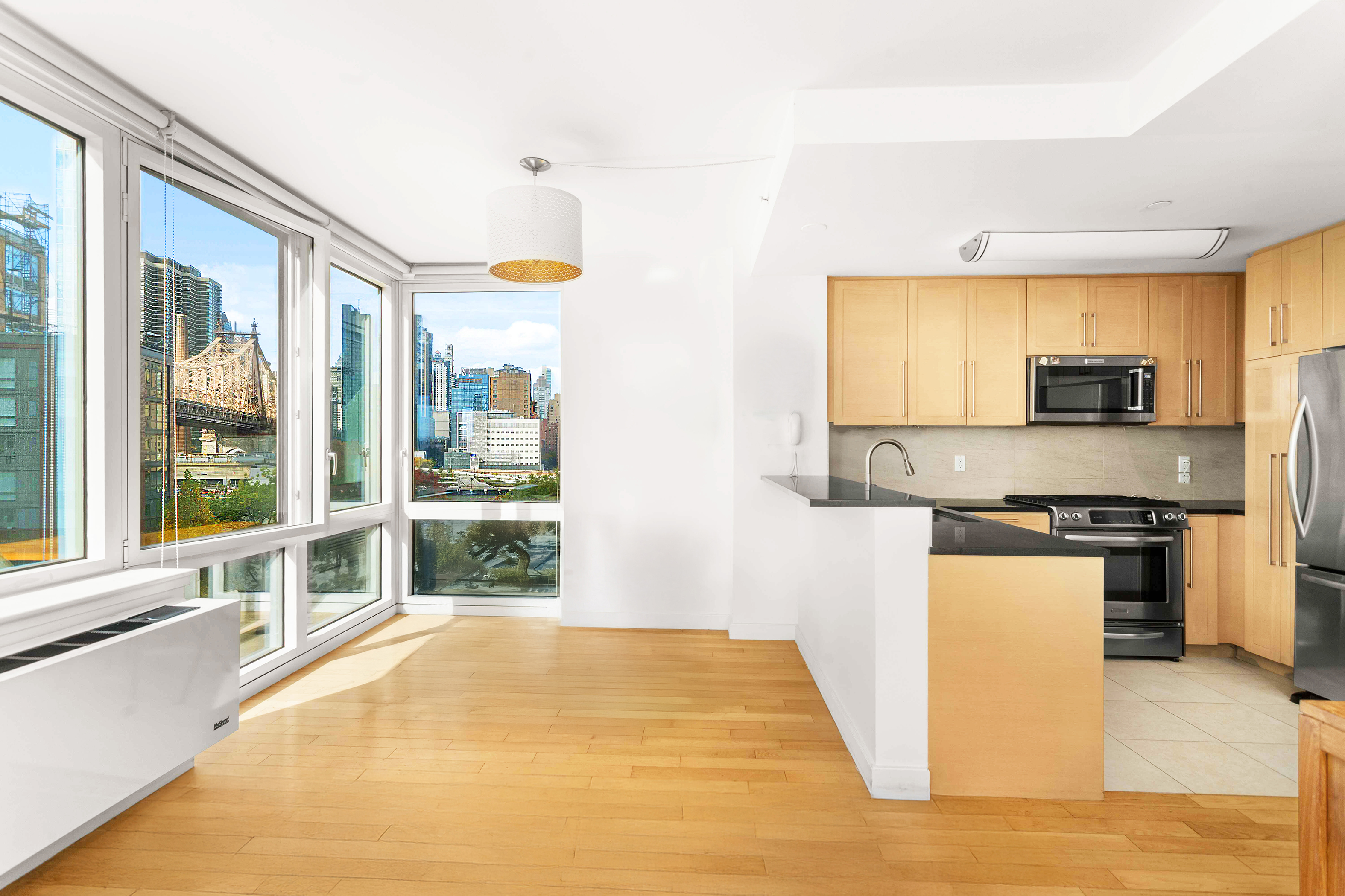 415 Main Street, Unit 7C Manhattan, NY 10044 - Photo 8 of 16 a large kitchen with stainless steel appliances a stove a sink and a refrigerator