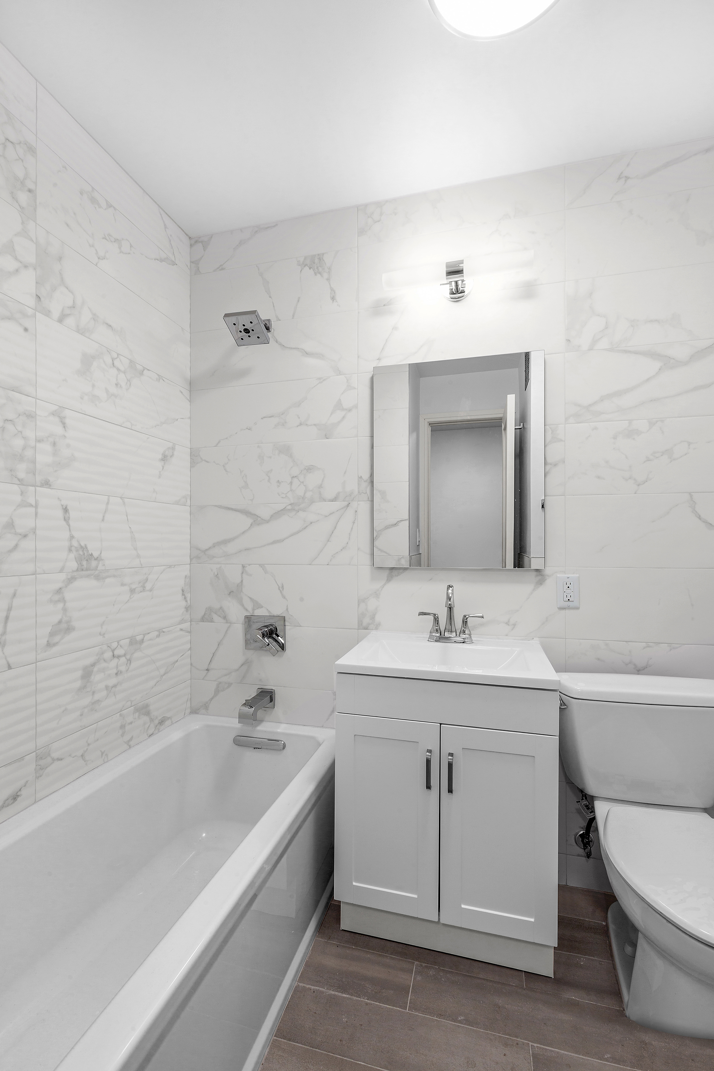 315 7th Avenue, Unit 8A Manhattan, NY 10001 - Photo 4 of 7 a bathroom with a bathtub sink vanity mirror and toilet