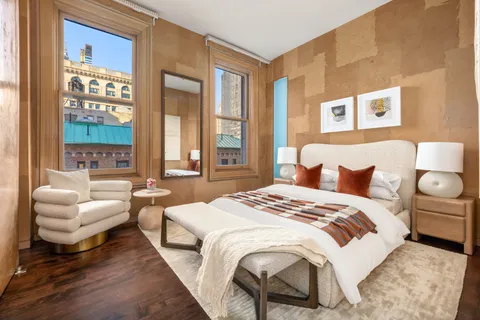 a spacious bedroom with a bed and glass windows