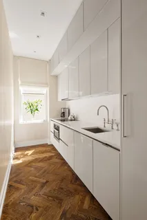a kitchen with granite countertop a sink a stove cabinets and entryway