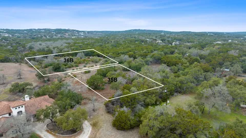 an aerial view of residential houses with outdoor space and trees