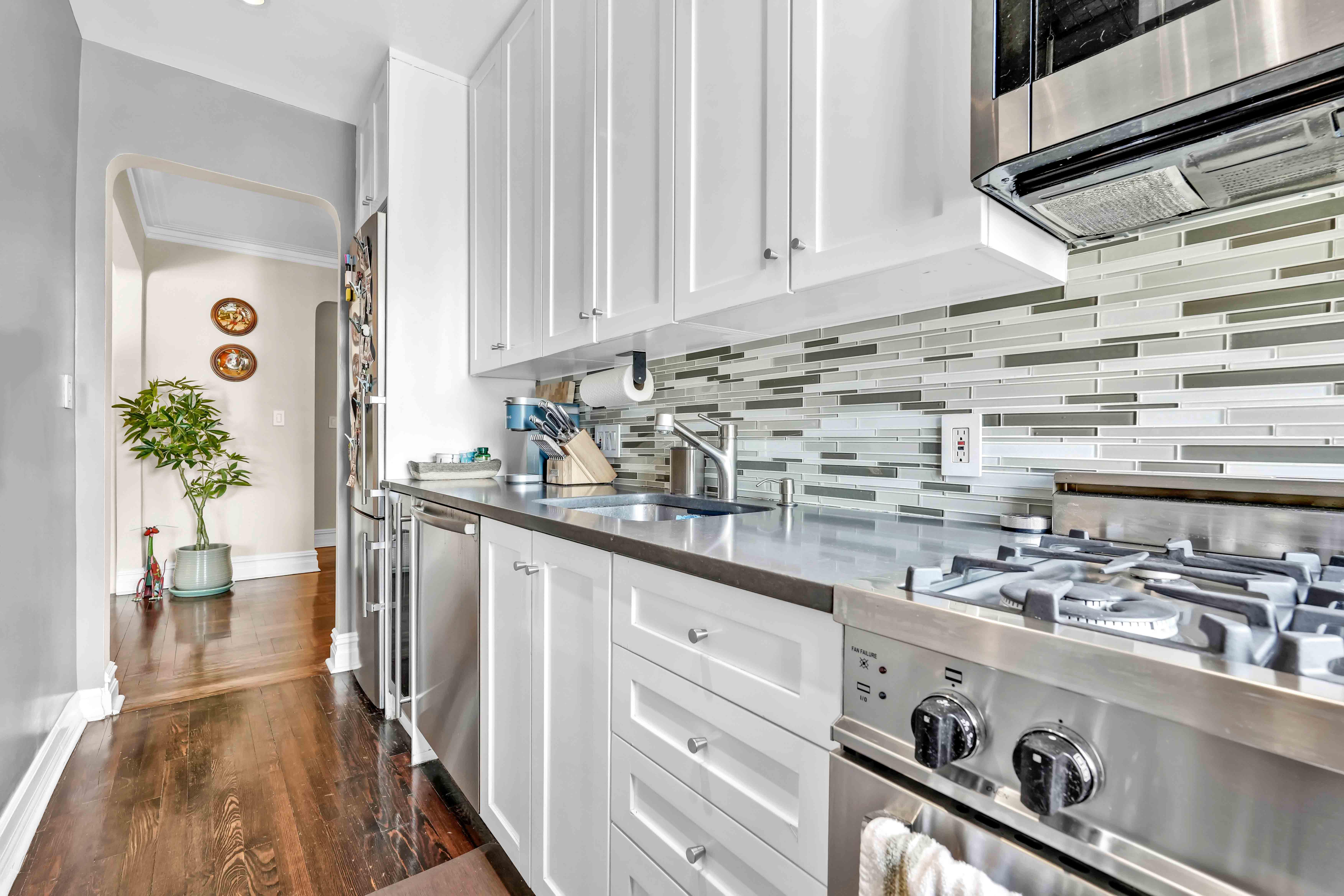 255 West 23rd Street, Unit 5GW Manhattan, NY 10011 - Photo 19 of 35 a kitchen with a stove and a white wooden cabinets