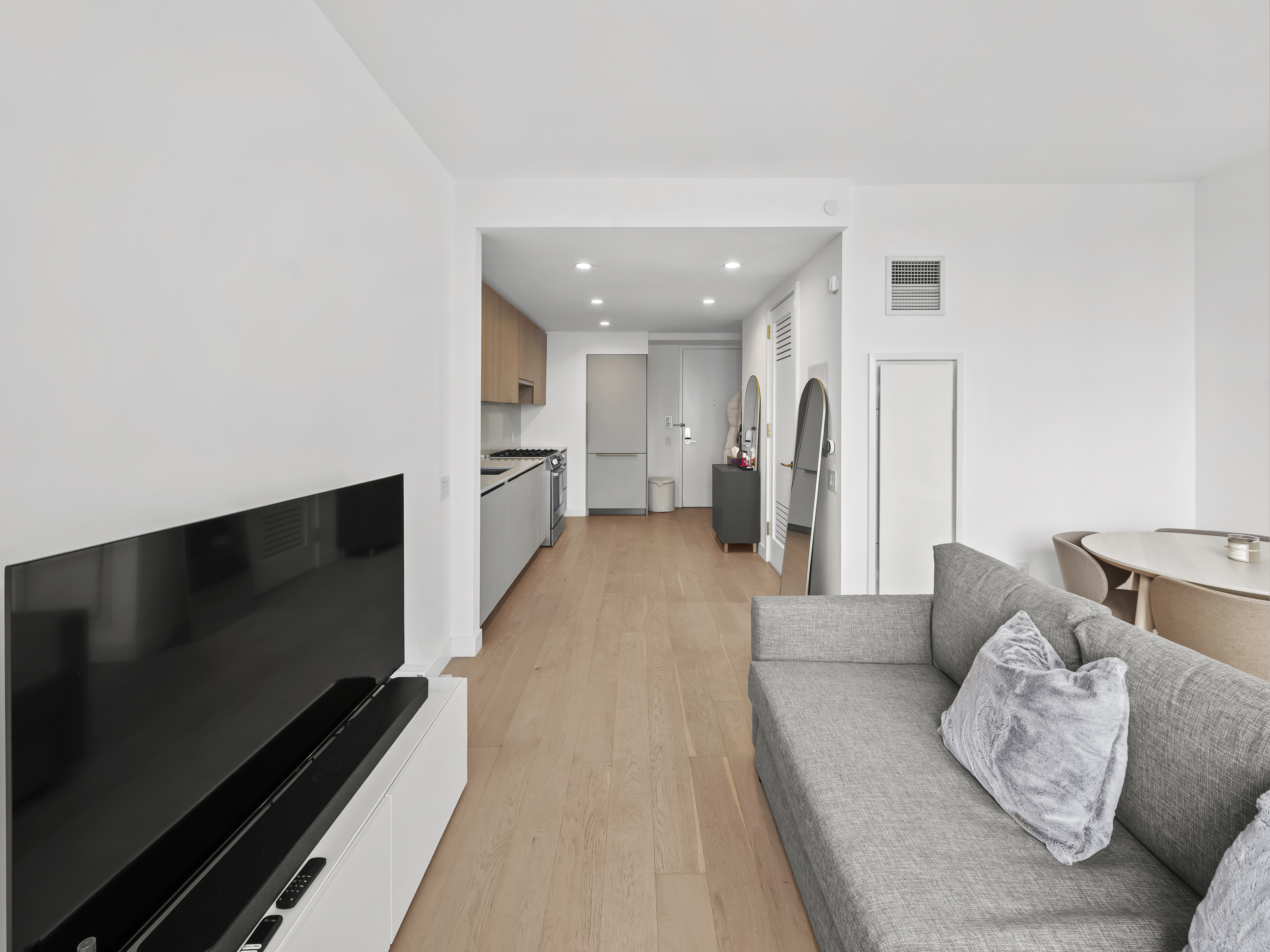45-3 Court Square, Unit 4406 Queens, NY 11101 - Photo 2 of 22 a living room with furniture and a flat screen tv