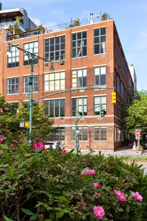 a building view with a lot of flower plants in front of it