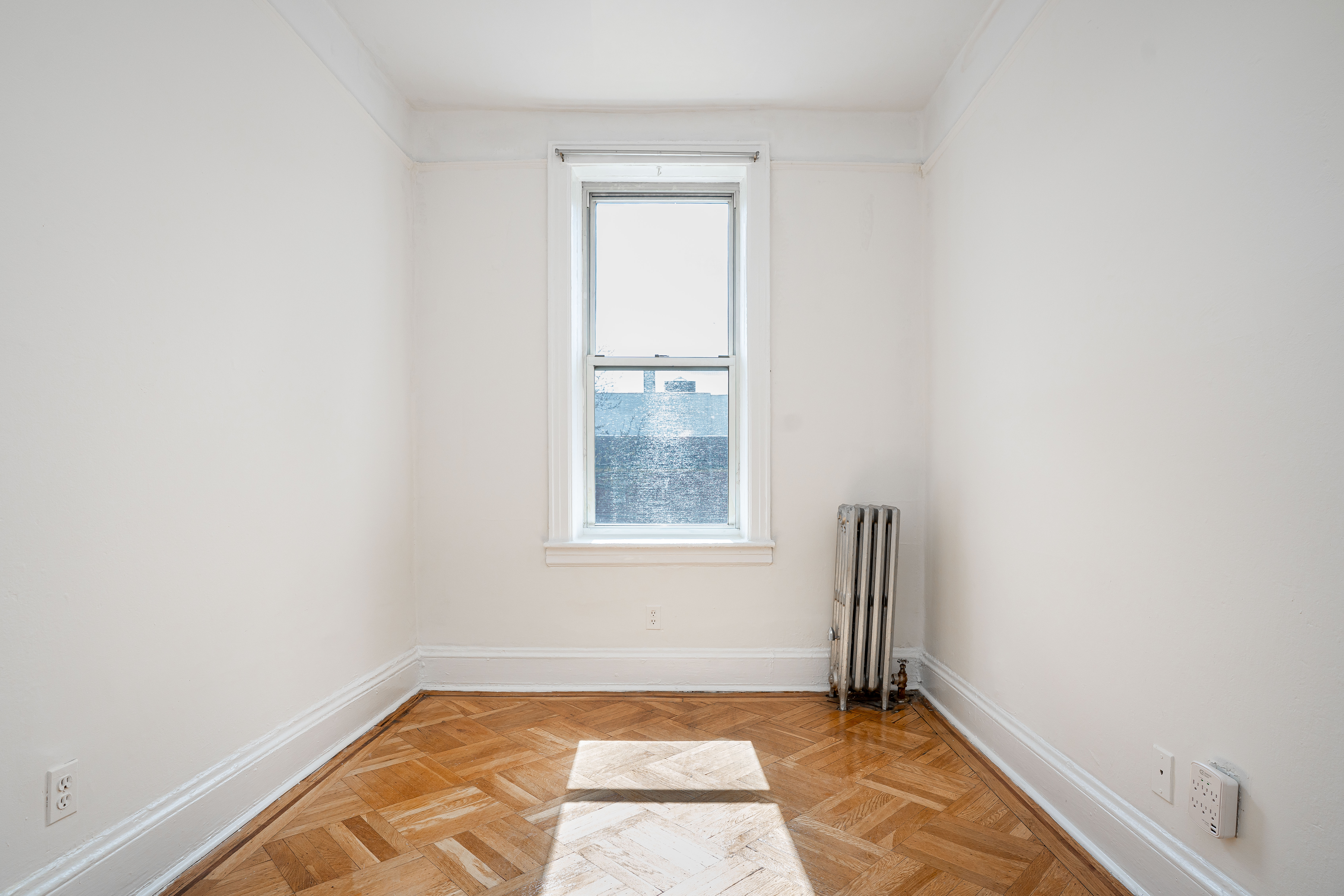 27-15 24th Avenue, Unit 2 Queens, NY 11105 - Photo 6 of 10 a view of an empty room and window