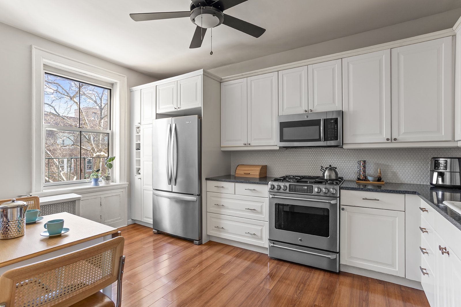 35-21 80th Street, Unit 52A Queens, NY 11372 - Photo 6 of 11 a kitchen with stainless steel appliances white cabinets a refrigerator a stove a sink and a window