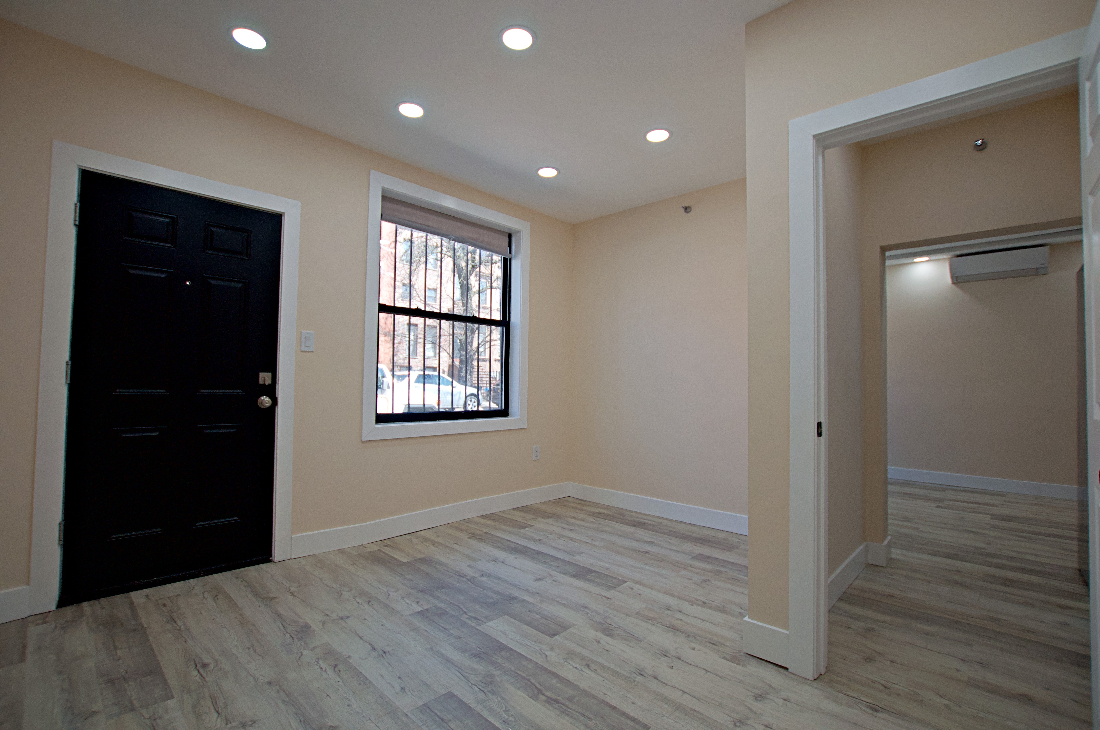 220 Madison Street, Unit 1A Brooklyn, NY 11216 - Photo 6 of 9 wooden floor in an empty room with a window