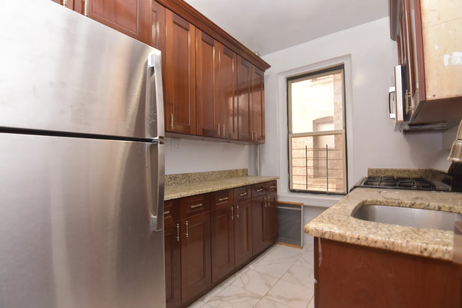 a kitchen with a refrigerator sink and cabinets