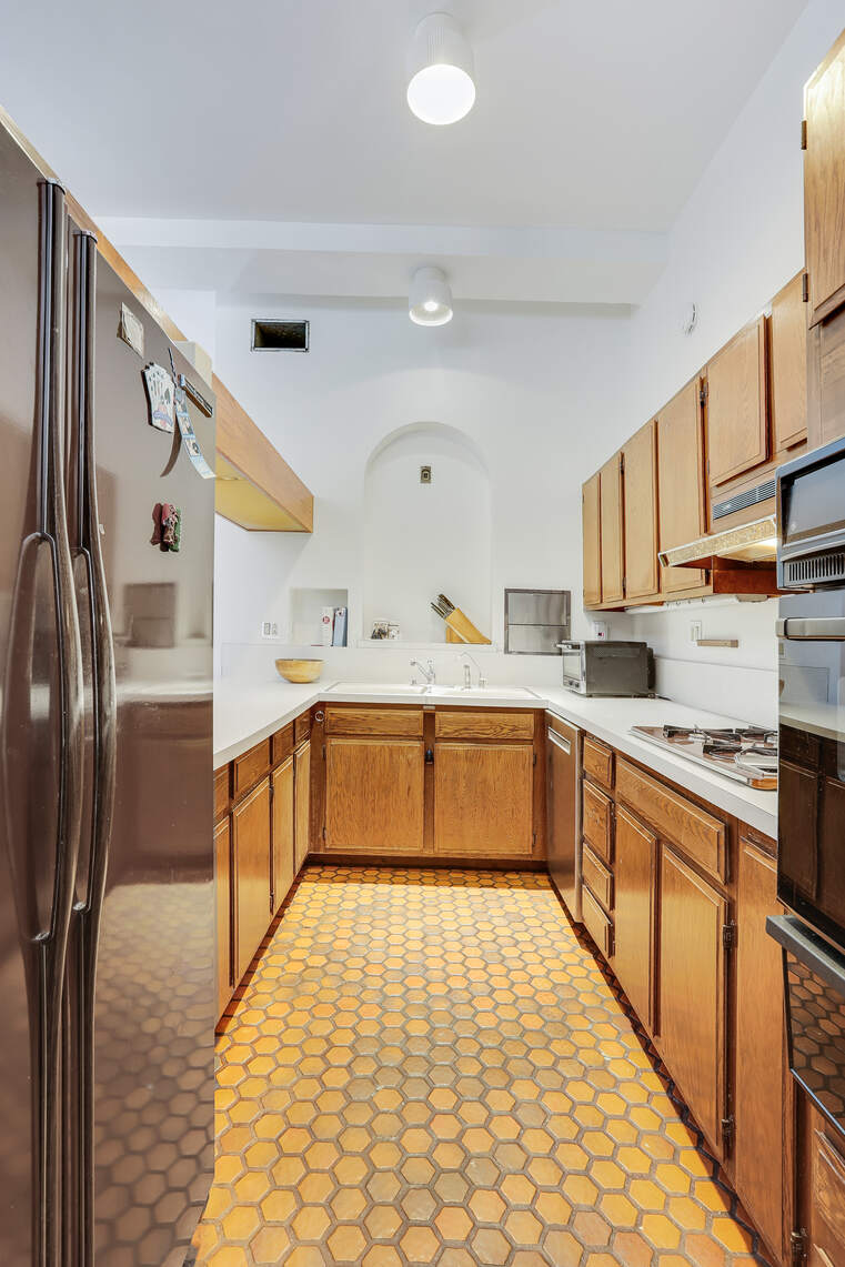 35 East 12th Street, Unit 8C Manhattan, NY 10003 - Photo 16 of 22 a kitchen with stainless steel appliances granite countertop a stove a sink and a refrigerator