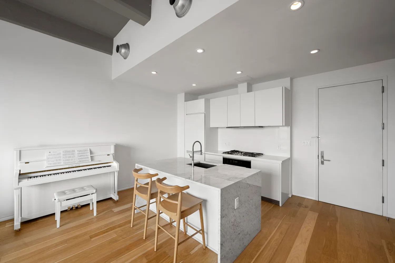 a kitchen that has a lot of cabinets and wooden floor