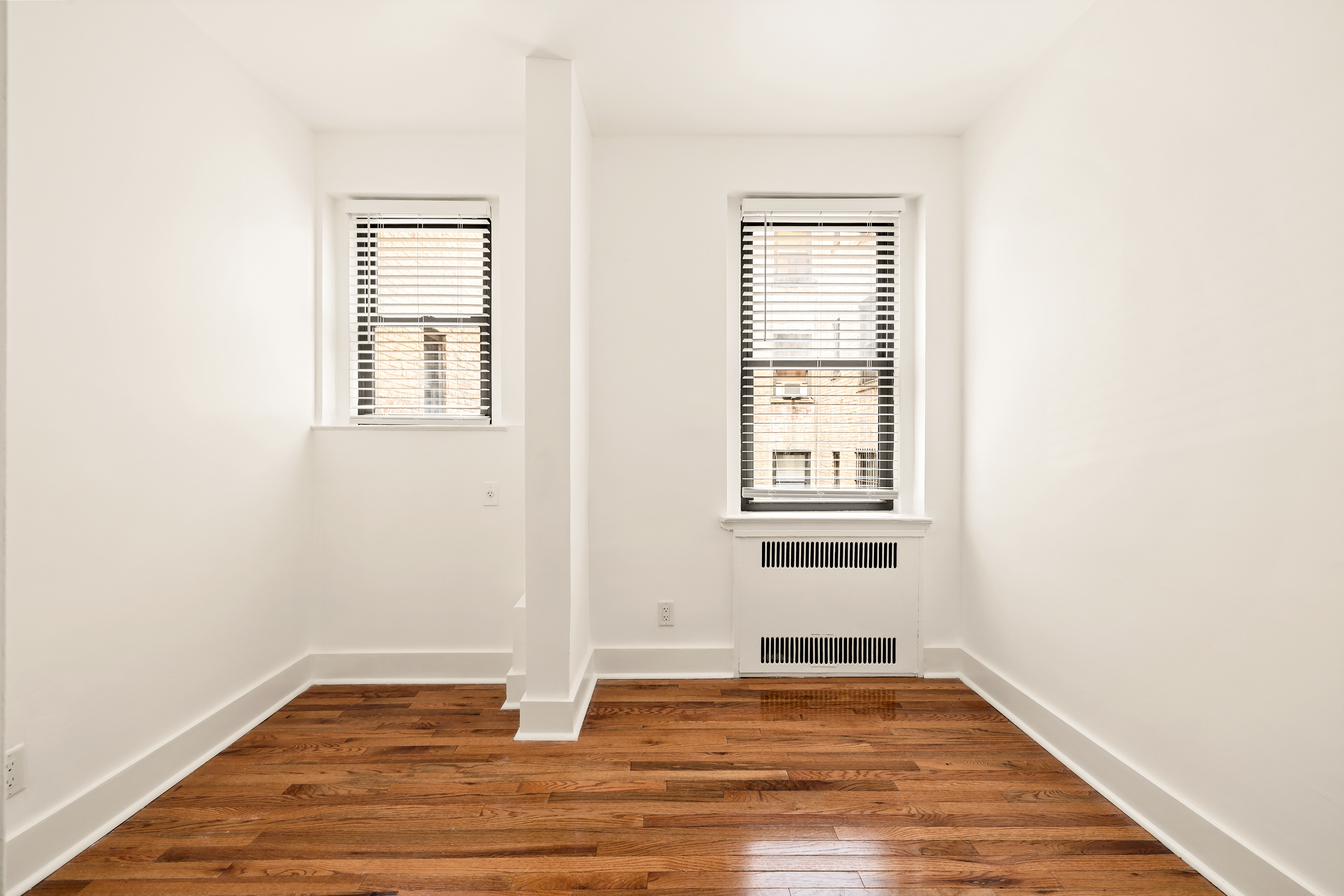 47-39 40th Street, Unit 1B Queens, NY 11104 - Photo 11 of 15 a view of an empty room with wooden floor and a window