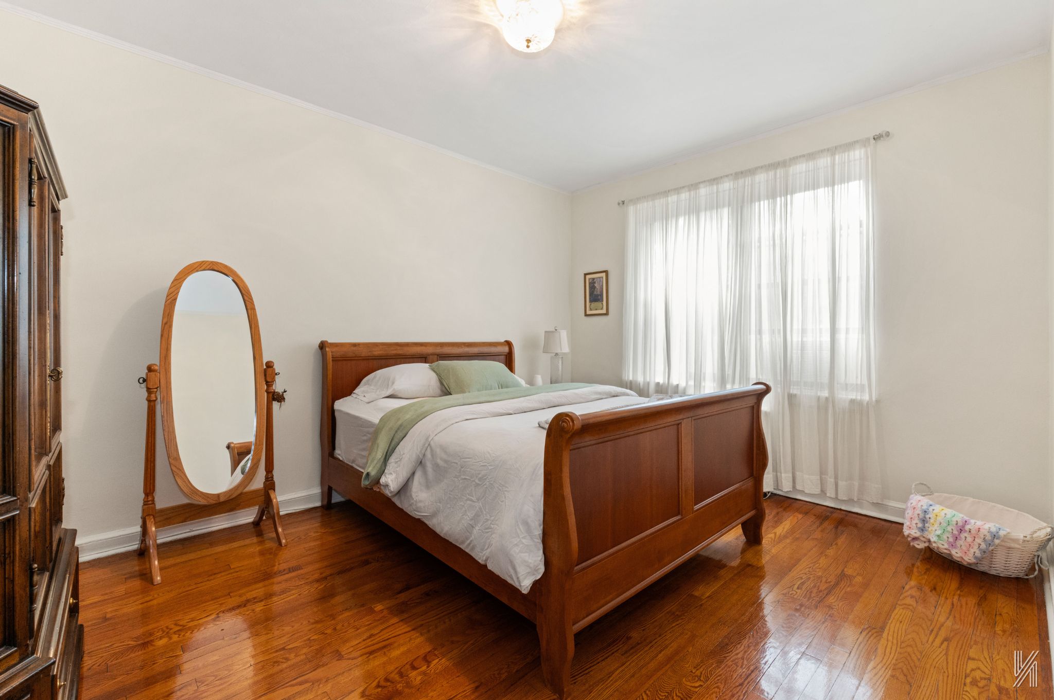 22-08 76th Street, Unit D2 Queens, NY 11370 - Photo 14 of 20 a bed sitting in a spacious bedroom next to a window