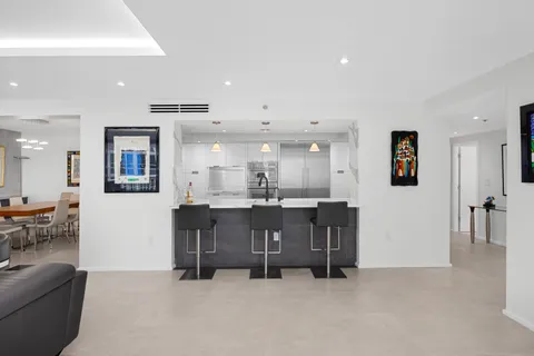 a large white kitchen with stainless steel appliances granite countertop a lot of counter space and wooden floors