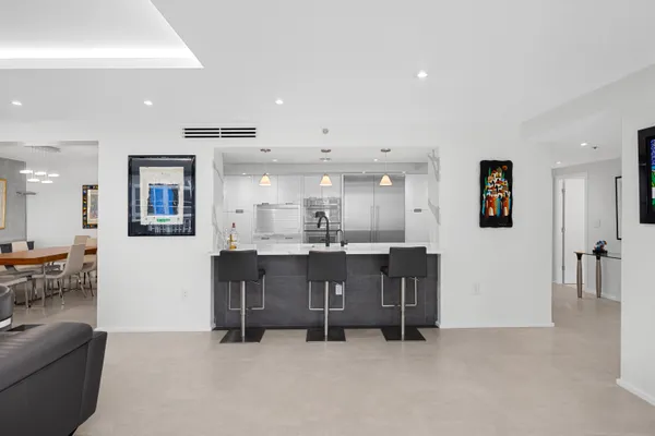 a large white kitchen with stainless steel appliances granite countertop a lot of counter space and wooden floors