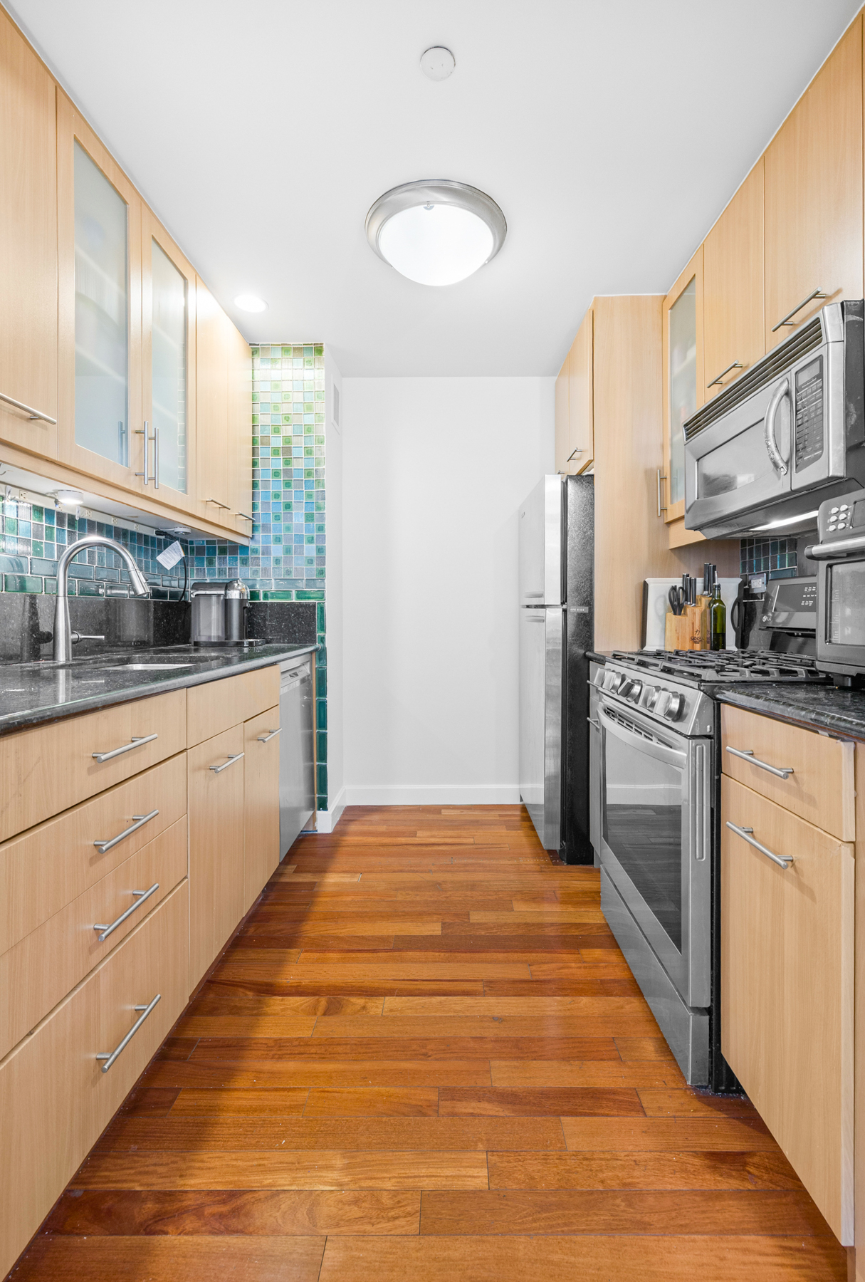 107-24 71st Road, Unit 2E Queens, NY 11375 - Photo 3 of 18 a kitchen with stainless steel appliances a sink cabinets and a window