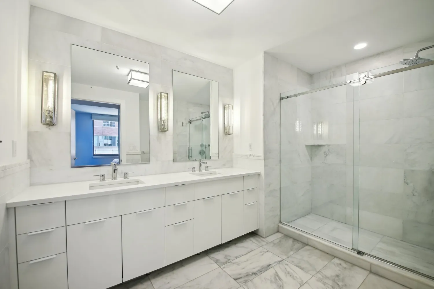 a bathroom with a double vanity sink mirror and shower