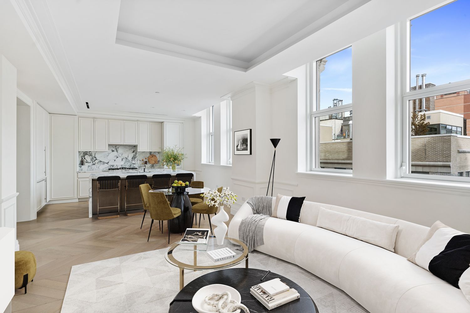 a living room with furniture kitchen view and large windows