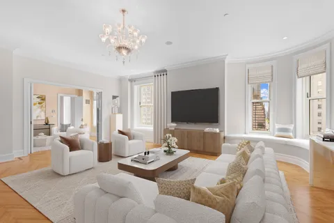 a living room with furniture a flat screen tv and a large window