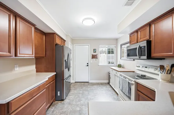 a kitchen with stainless steel appliances granite countertop a refrigerator stove and sink