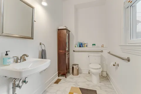 a bathroom with a sink toilet and a mirror