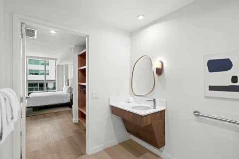 a en suite bathroom with a double vanity sink a mirror and a bathtub
