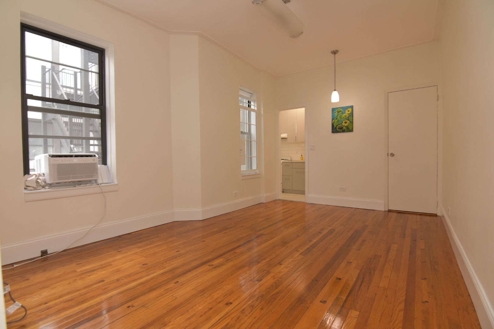 668 Riverside Drive, Unit 5A Manhattan, NY 10031 - Photo 2 of 8 a view of an empty room with wooden floor and a window