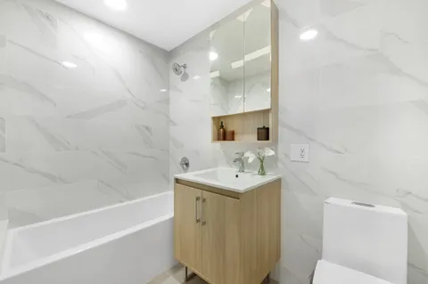 a bathroom with a sink a toilet and shower