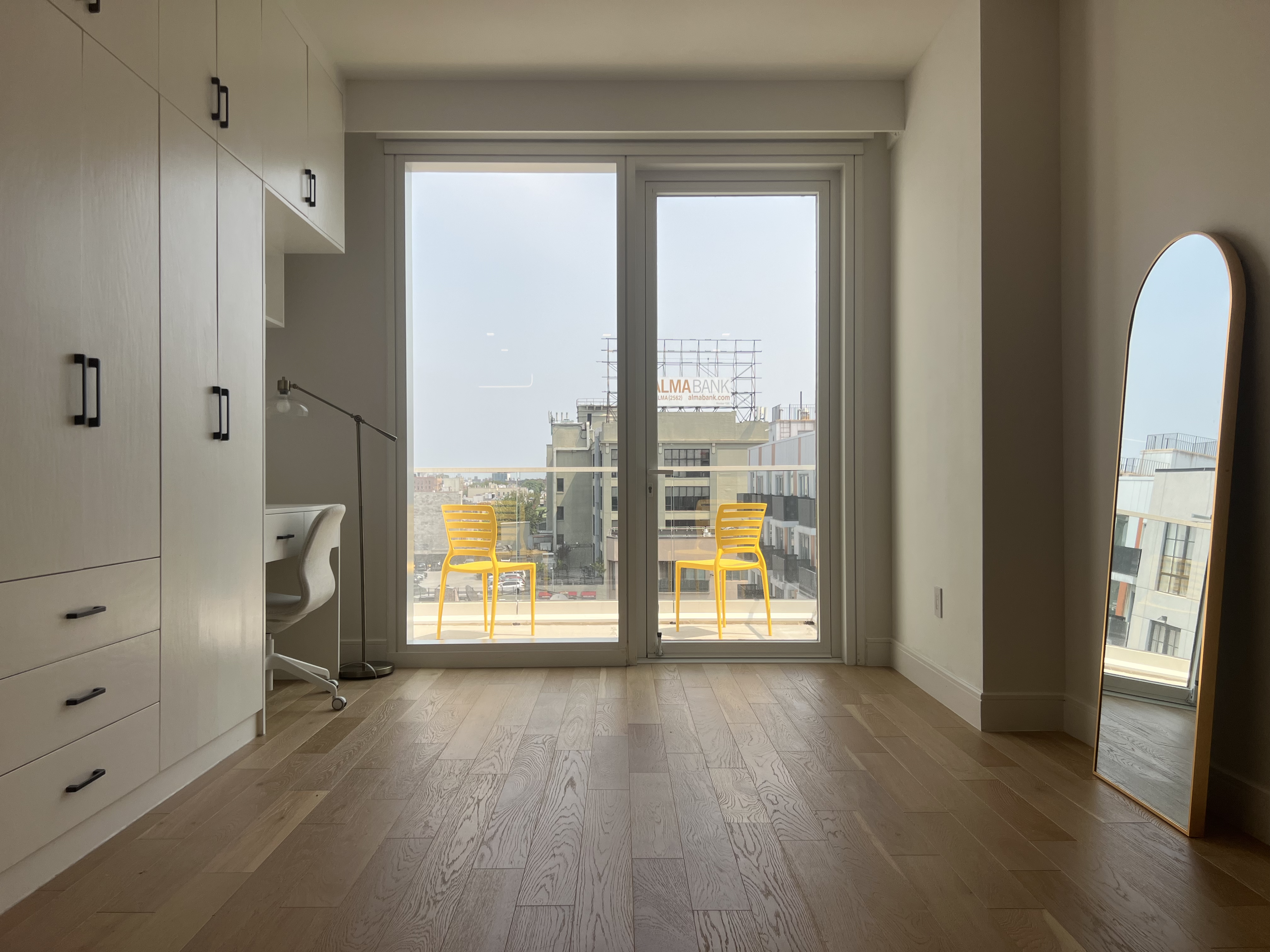 37-34 33rd Street, Unit 7H Queens, NY 11101 - Photo 6 of 18 a view of an empty room with a window and wooden floor