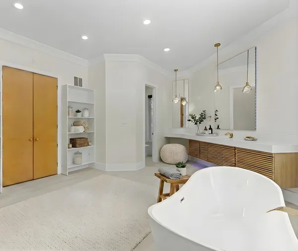 a bathroom with a tub a sink and a large mirror