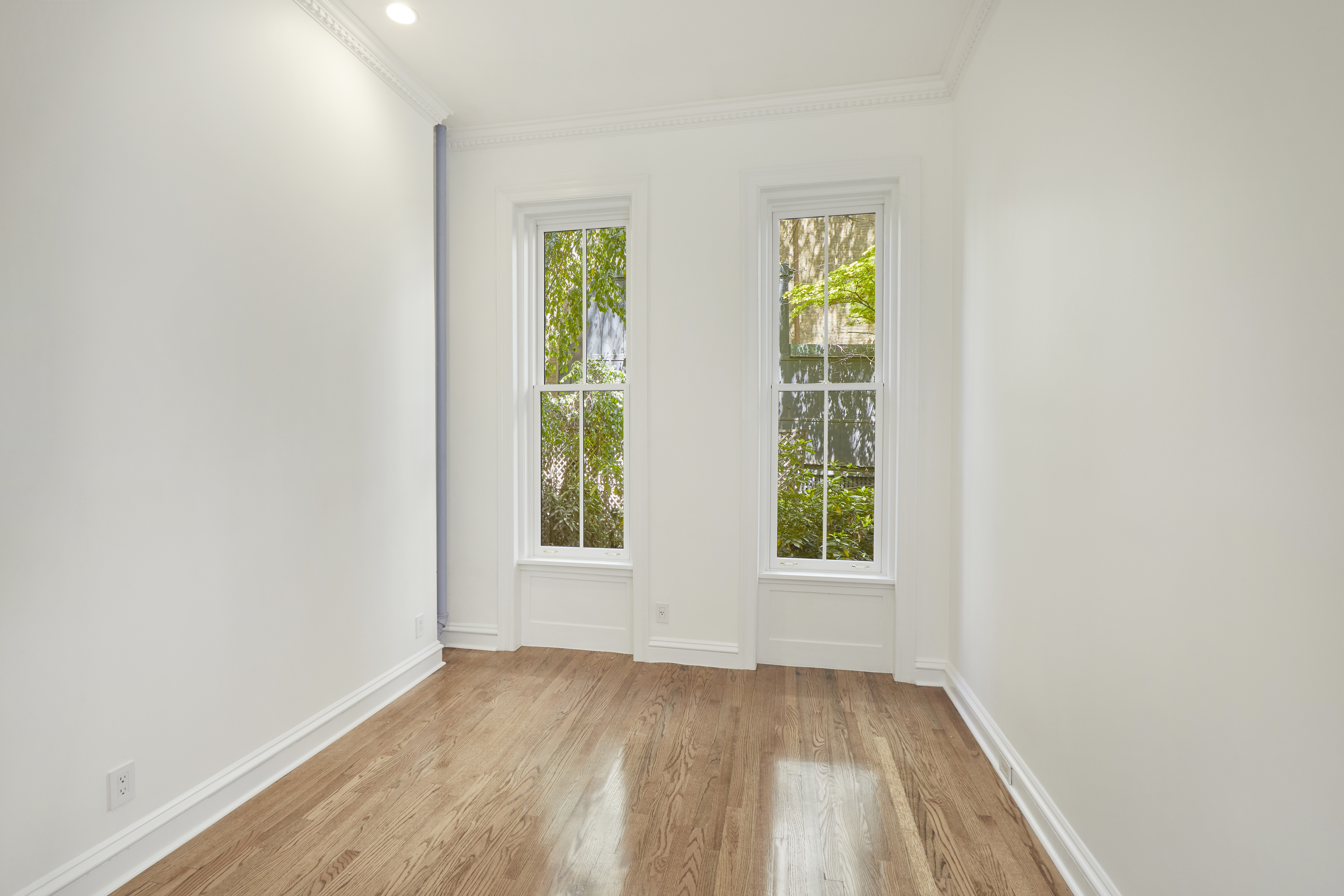 157 East 75th Street, Unit 1E Manhattan, NY 10021 - Photo 15 of 21 an empty room with window and wooden floor