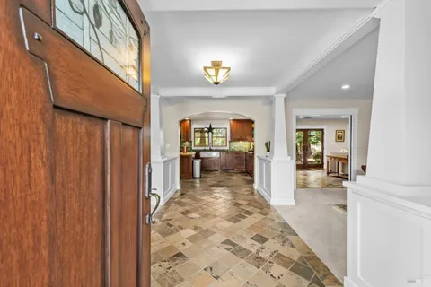 a living room with furniture large window and wooden floor