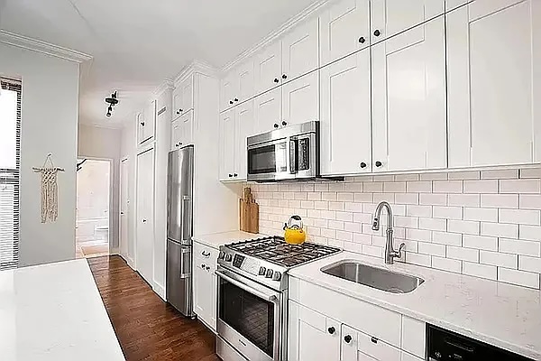 314 West 94th Street, Unit 5E Manhattan, NY 10025 - Photo 6 of 7 a kitchen with stainless steel appliances granite countertop white cabinets a stove top oven a sink and dishwasher