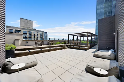 a living room with stainless steel appliances furniture a clock and a table