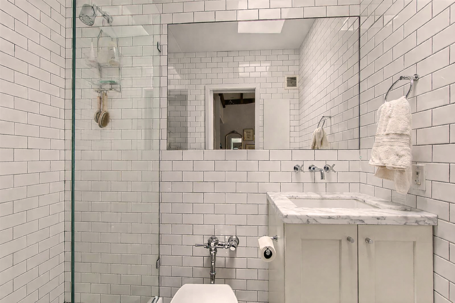 56 Jane Street, Unit 4B Manhattan, NY 10014 - Photo 4 of 5 a bathroom with a sink and mirror