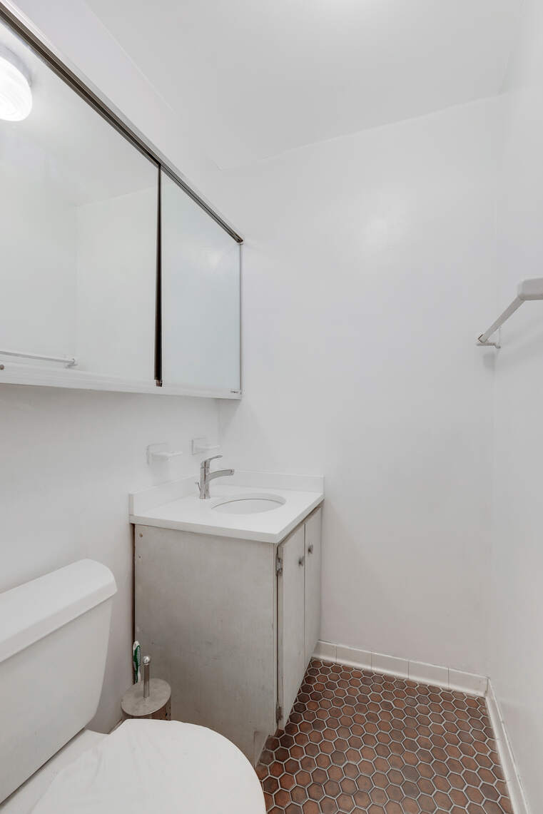 310 East 23rd Street, Unit 5A Manhattan, NY 10010 - Photo 9 of 14 a bathroom with a toilet a sink and mirror