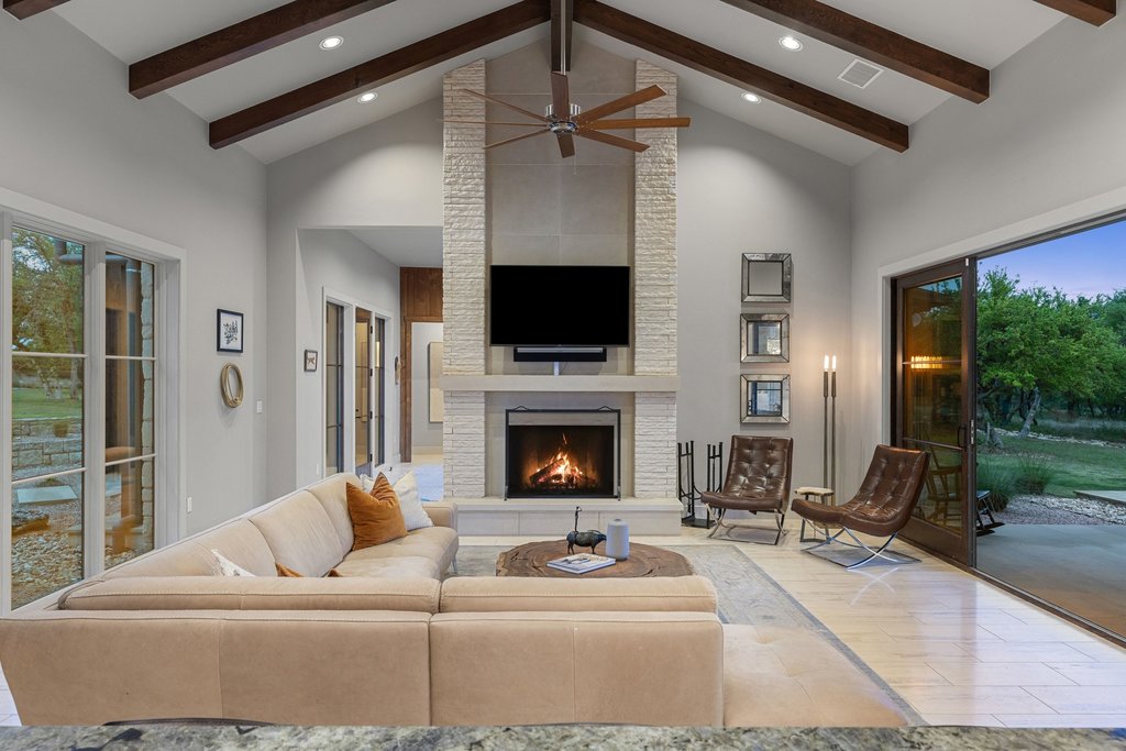 2560 Bell Springs Road Dripping Springs, TX 78620 - Photo 30 of 42 a living room with furniture a fireplace and a flat screen tv