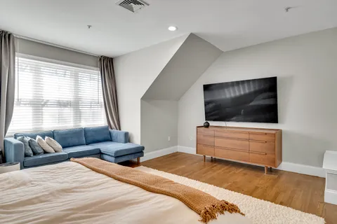 a bedroom with furniture and a flat screen tv