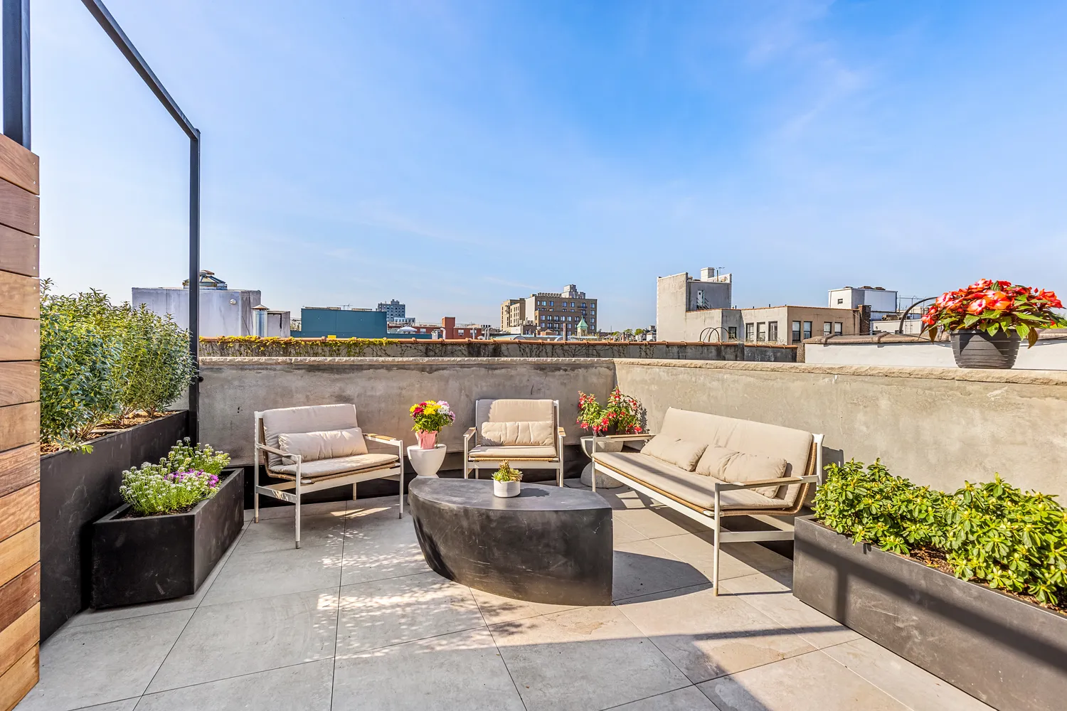 a view of a roof deck with couches and potted plants
