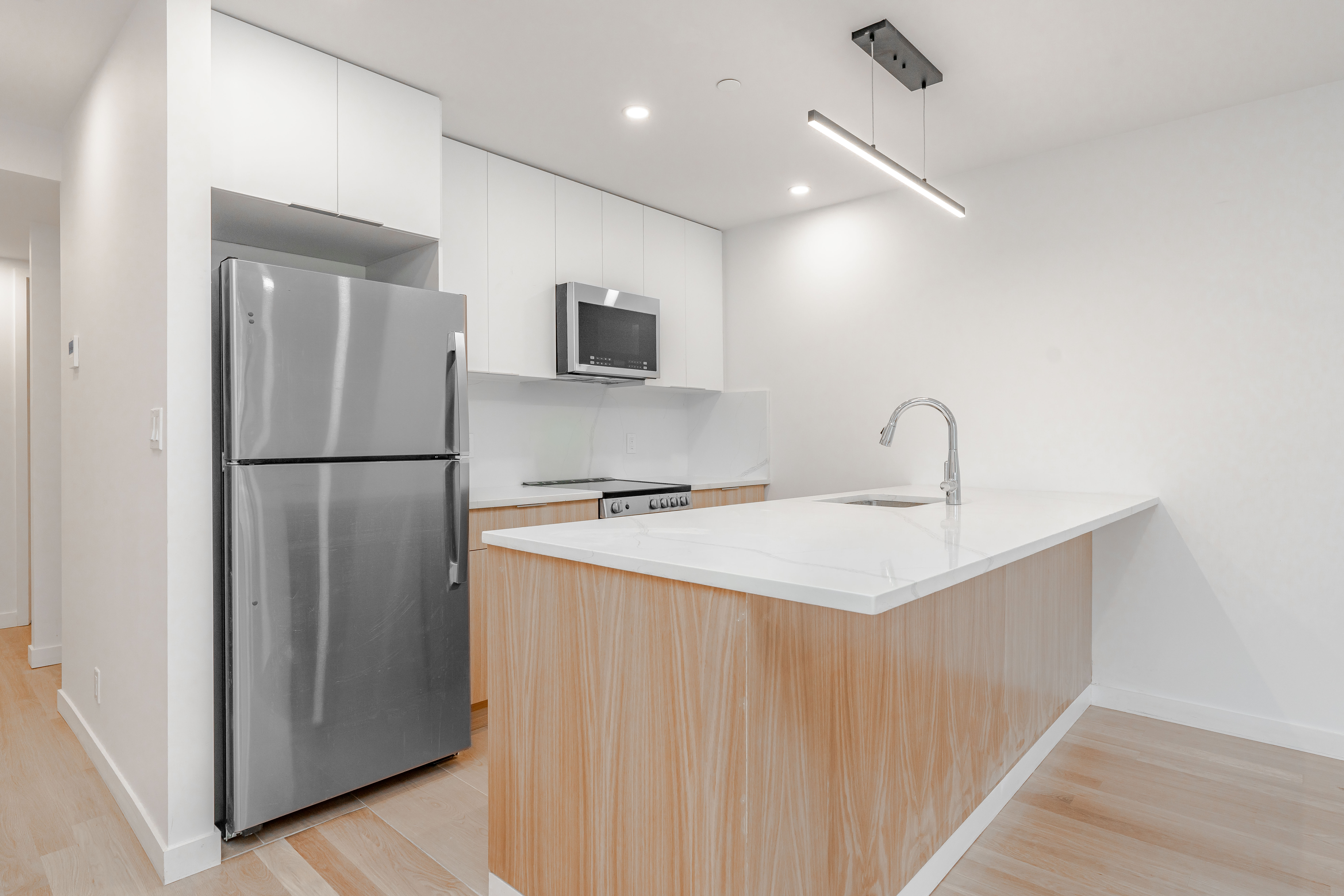 20-15 46th Street, Unit 2 Queens, NY 11105 - Photo 1 of 16 a kitchen with a refrigerator a sink and cabinets