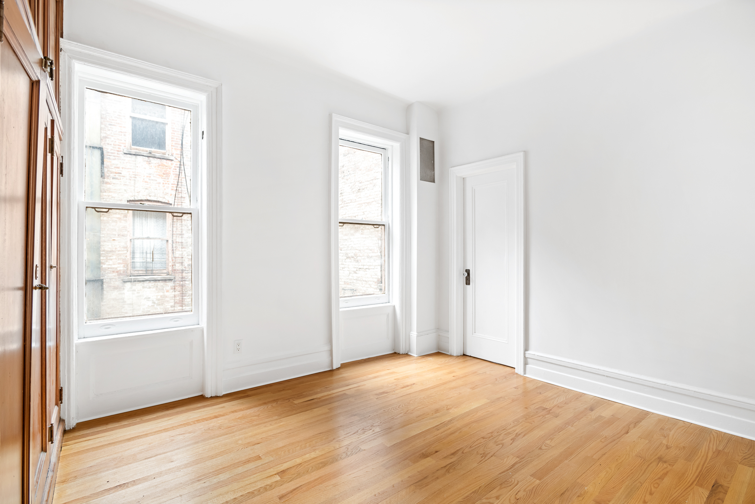 50 East 96th Street, Unit 5D Manhattan, NY 10128 - Photo 4 of 5 an empty room with wooden floor and windows